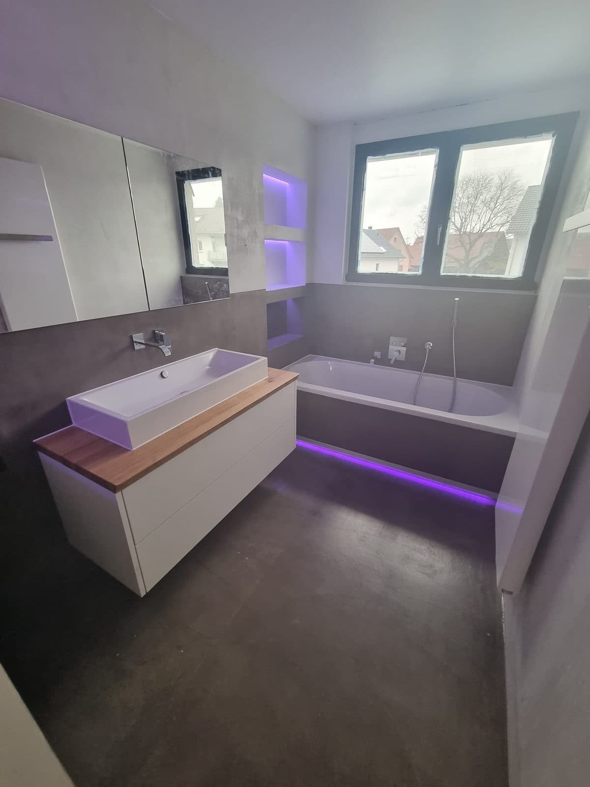 Łazienka z szarymi płytkami wielkoformatowymi, wanną w zabudowie i podświetleniem LED – Szczawno-Zdrój